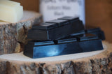 Black coloured felters wax on a log slice display board.