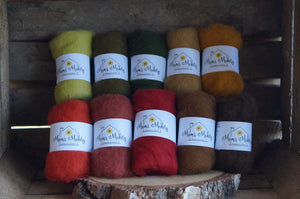 10 autumnal shades of felting wool on a rustic wooden background